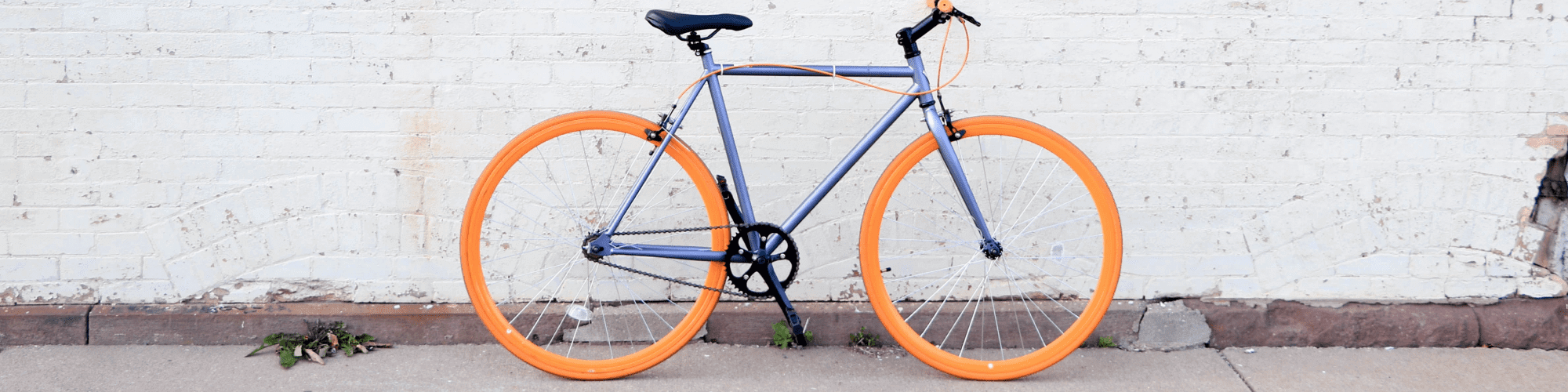 bike with brightly colored tires in front of a white brick wall