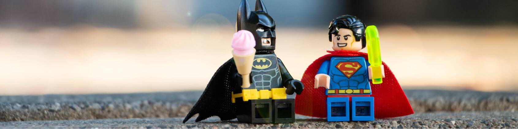 a macro photo of lego batman and lego superman hanging out