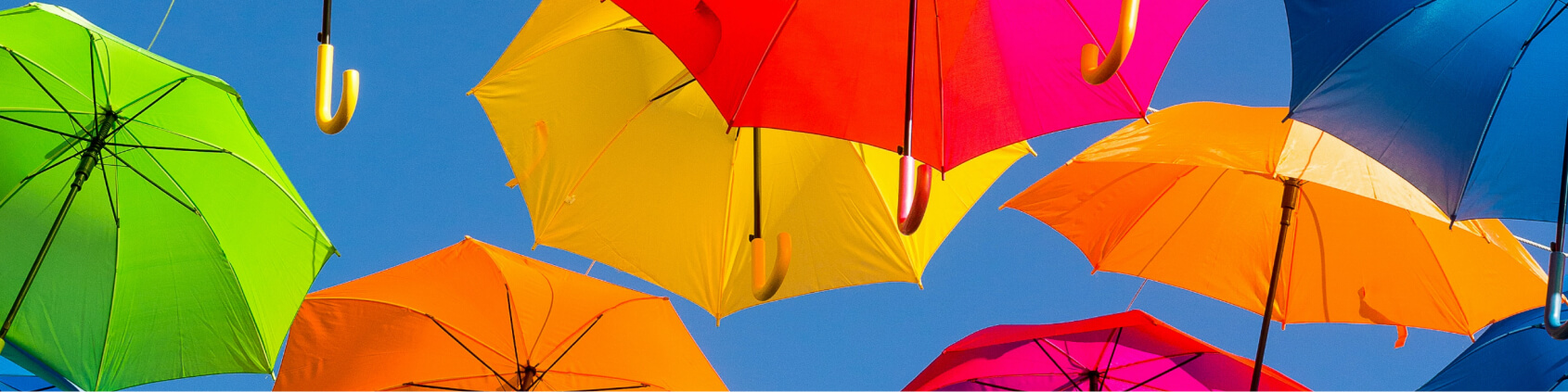 Colourful umbrellas against a blue sky